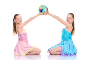 Girls gymnasts perform exercises with the ball.