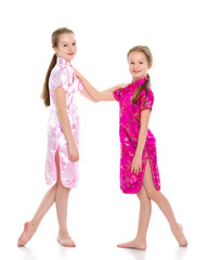 Girls are sisters in Chinese national dresses.