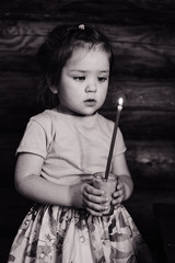 little girl holding a candle black and white photo