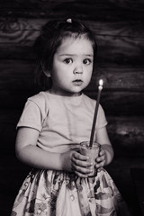 little girl holding a candle black and white photo