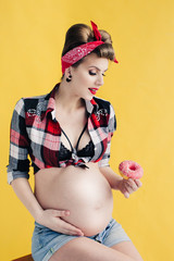 pregnant girl in pin-up style with donut in hand