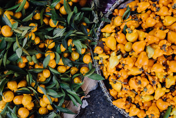 tangerines and yellow fruits in large baskets.