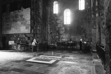 Visitor praying in Tatev Monastery, Armenia