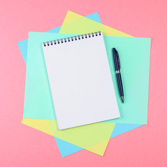 Top view flat lay picture with blank notepad page and different accessories on colored surface.