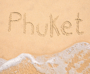 The word Phuket written in the sand on beach