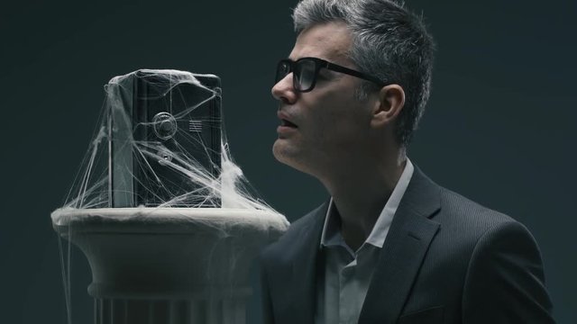 Businessman and dusty safe with cobwebs