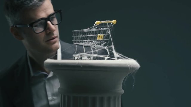 Business executive and dusty miniature shopping cart