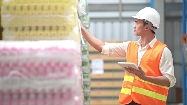 Quality inspector in small warehouse. Young chinese male inspector inspecting small warehouse safety in real warehouse.