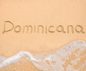 The word Dominicana written in the sand on beach