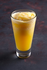Glass of orange granizado. Crushed ice with fruit syrup beverage.