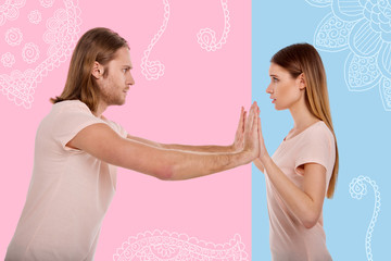 Fototapeta premium Strength. Young worried woman feeling scared while her strong serious boyfriend showing his strength