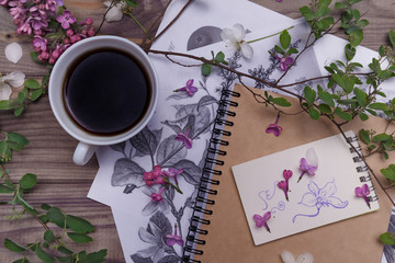 Beautiful violet lilac flowers with white cup with coffee or tea, on a wooden background