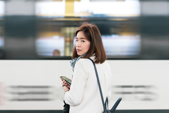 A girl is wating a train in a trian station at Geneva, Switzerland.