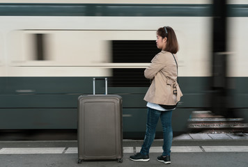 A girl is wating a train in a trian station at Geneva, Switzerland.