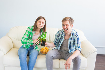 Soccer world cup concept - Couple of friends sitting in sofa watching sport game on tv