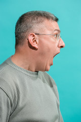 Obraz premium The young attractive man looking suprised isolated on blue