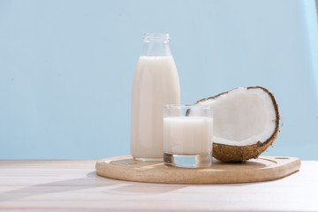Coconut milk in bottle and glass on table with copy space