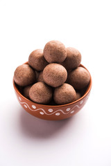 Nachni laddu or Ragi laddoo or balls made using  finger millet, sugar and ghee. It's a healthy food from India. Served in a bowl or plate over moody background. Selective focus