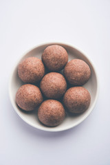 Nachni laddu or Ragi laddoo or balls made using  finger millet, sugar and ghee. It's a healthy food from India. Served in a bowl or plate over moody background. Selective focus