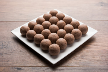 Nachni laddu or Ragi laddoo or balls made using  finger millet, sugar and ghee. It's a healthy food from India. Served in a bowl or plate over moody background. Selective focus
