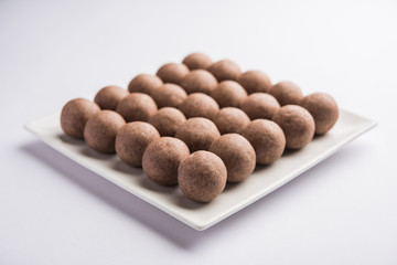 Nachni laddu or Ragi laddoo or balls made using  finger millet, sugar and ghee. It's a healthy food from India. Served in a bowl or plate over moody background. Selective focus