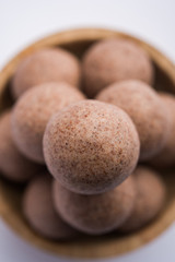 Nachni laddu or Ragi laddoo or balls made using  finger millet, sugar and ghee. It's a healthy food from India. Served in a bowl or plate over moody background. Selective focus