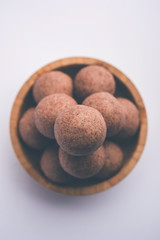 Nachni laddu or Ragi laddoo or balls made using  finger millet, sugar and ghee. It's a healthy food from India. Served in a bowl or plate over moody background. Selective focus