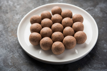 Nachni laddu or Ragi laddoo or balls made using  finger millet, sugar and ghee. It's a healthy food from India. Served in a bowl or plate over moody background. Selective focus