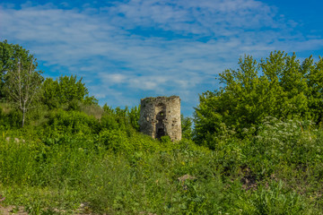 Fototapeta na wymiar one old medieval destroyed tower in summer green nature environment