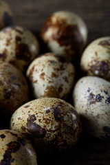 Obraz premium Spotted quail eggs arranged on the background of old wooden boards, with copy-space, selective focus.