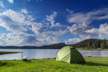 Tent near the dam under the beautiful clouds