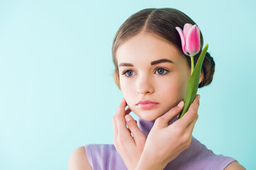 portrait of tender youth girl with spring flower, isolated on turquoise