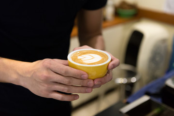 Barista man holding cup of coffee.