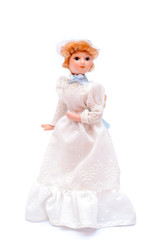 Porcelain doll in vintage white dress and hat, front view