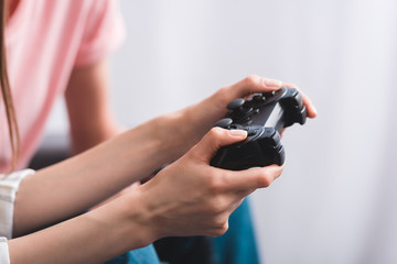cropped image of woman holding joystick and playing video game with friend