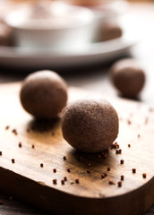 Nachni laddu or Ragi laddoo or balls made using  finger millet, sugar and ghee. It's a healthy food from India. Served in a bowl or plate with raw whole and powder. Selective focus