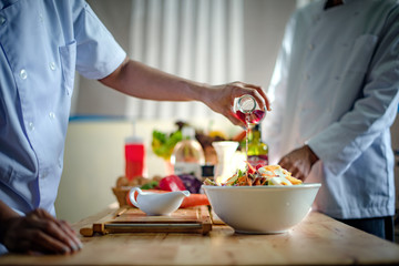 red venegar souce pour fill on topping of assorted vegetable salad in bowl, cooking and prepare by chef serving forward