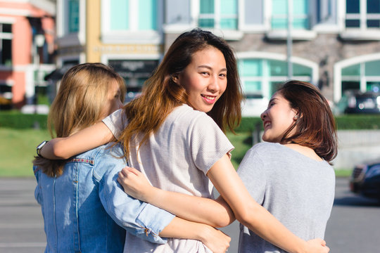 Happy young Asian women group city lifestyle playing and chatting each other among the pastel building city on weekend. City lifestyle of girls group. City lifestyle and outdoor activity concept.