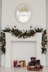 white fireplace decorated by christmas ornaments