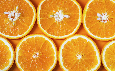 orange cut into slices on an orange background