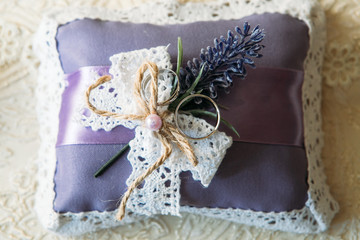 Wedding rings on a purple cushion