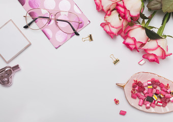 Roses and cute feminine accessories on the white table,