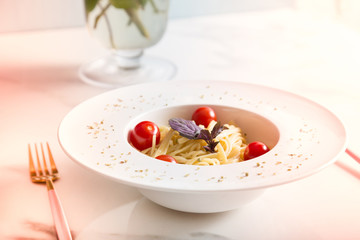 Spaghetti pasta with cherry tomatoes on white plate