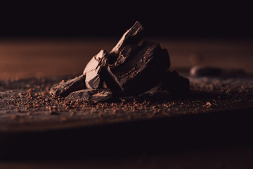 closeup view of grated chocolate and pieces of chocolate on wooden table