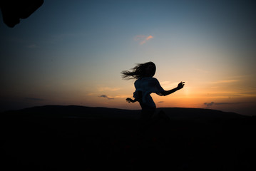 Silhouette of a young woman on a sunset