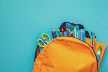 Back to school concept. Backpack with school supplies. Top view. Copy space. Toned