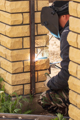 Fototapeta premium Welder welds metal at the construction site