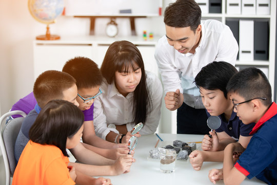 Asian Teacher Expanding To Student In Geology Class With Different Of Rock .