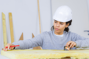 woman carpenter measuring wood