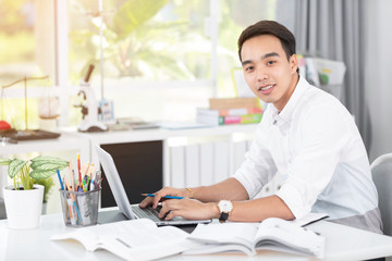 Fototapeta na wymiar Young Asian man university student working with laptop computer.